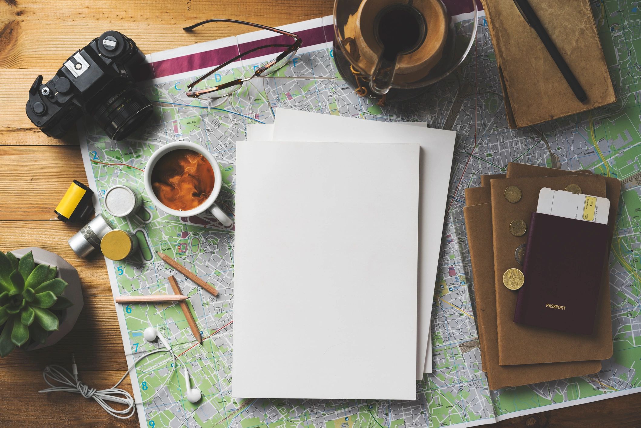 Travel planning flat lay with map, coffee, passport, and notebook