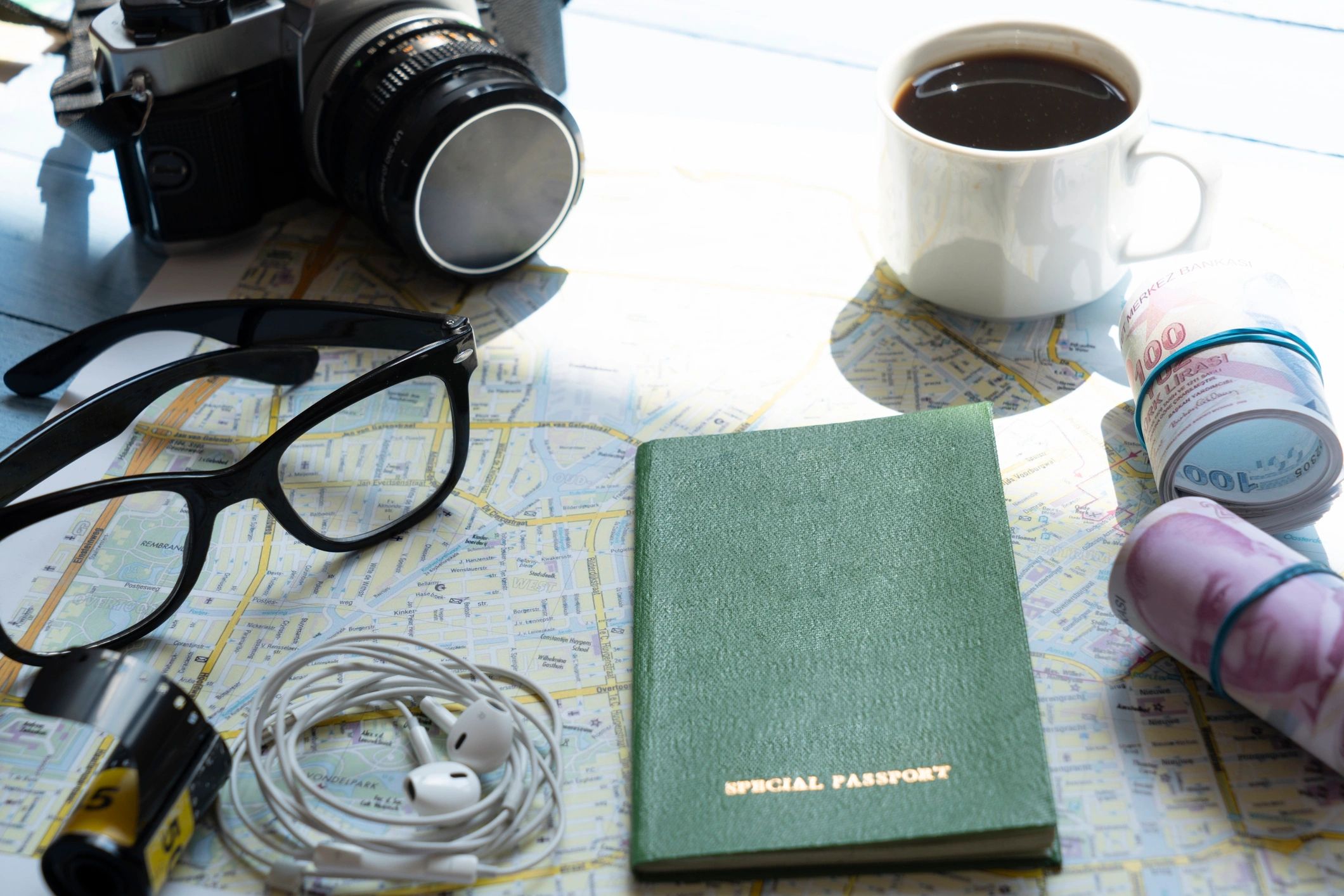 Travel flat lay with map, passport, camera, and coffee
