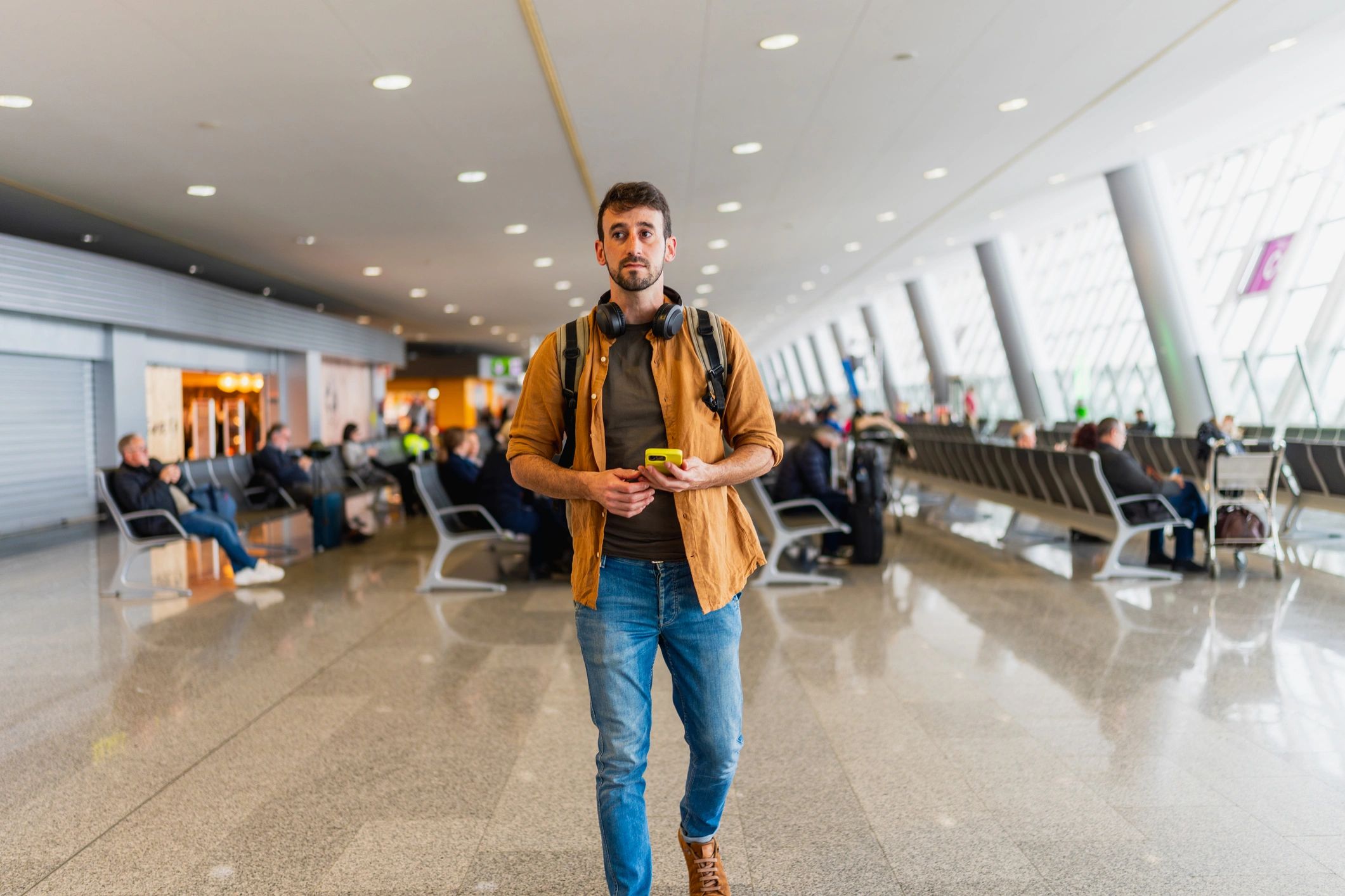 Solo traveler walking through an airport terminal with backpack