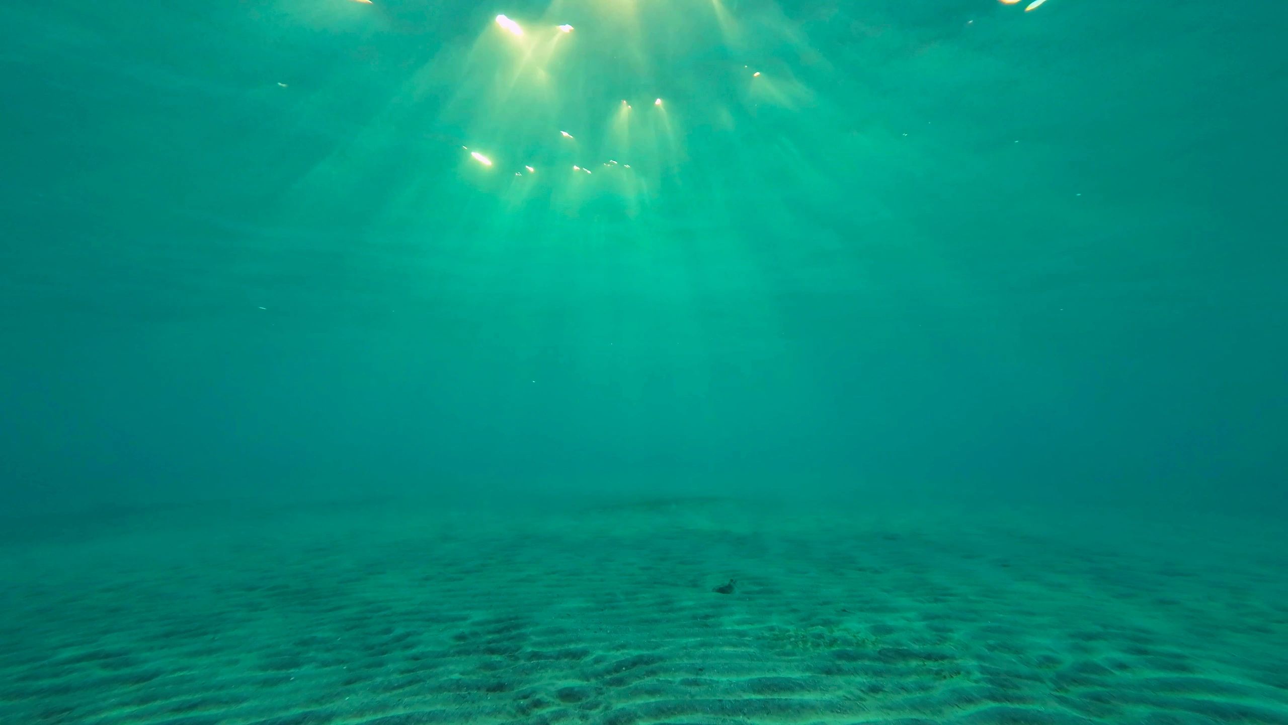 Underwater sun rays penetrating the surface of the sea